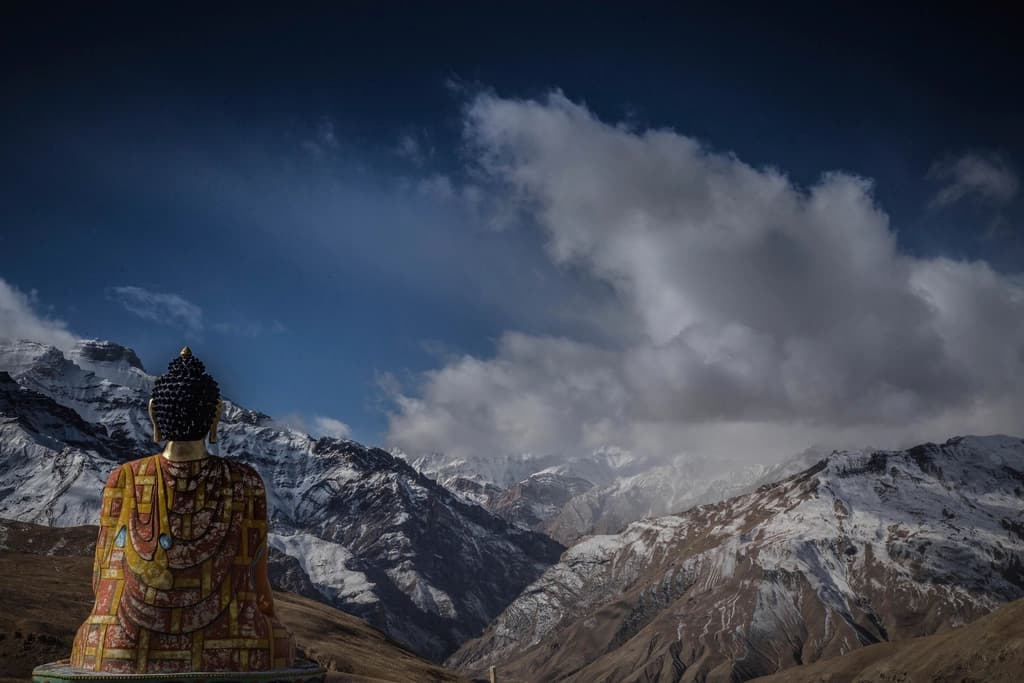 A seated Buddha looking out over the snow line